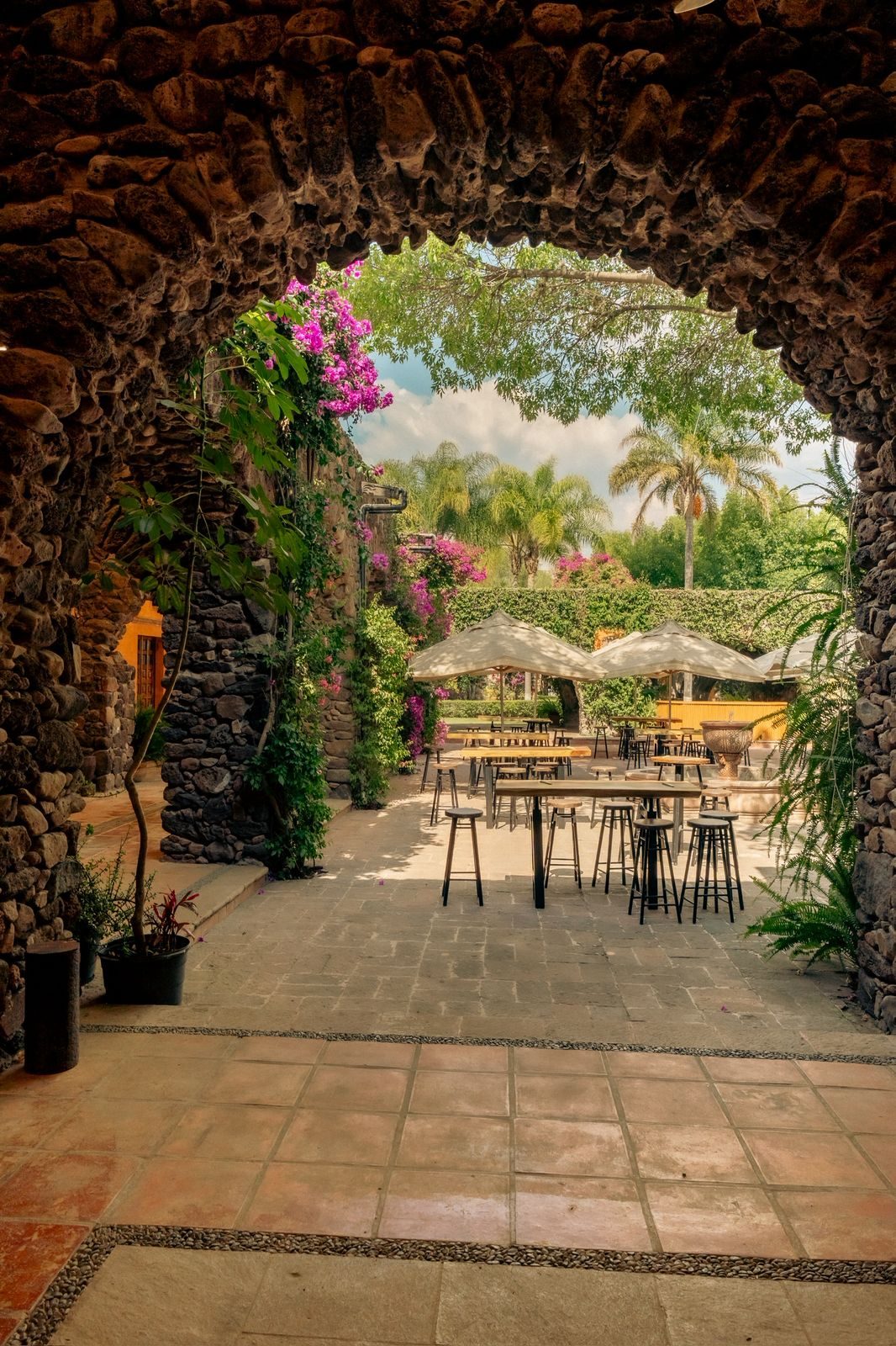 Arco de piedra con buganvilia y terraza en Hacienda Dolores, Querétaro