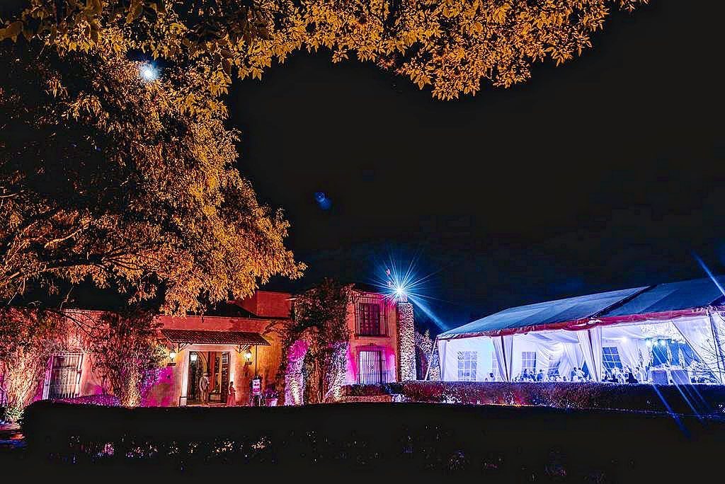 Fachada iluminada en rosa y azul para evento nocturno en Hacienda Dolores, Querétaro
