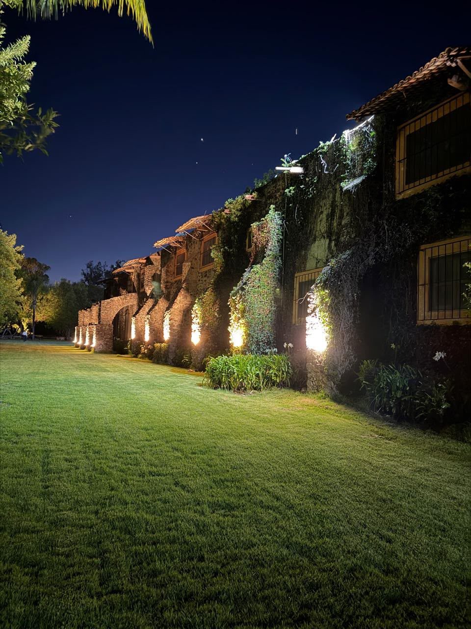 Fachada iluminada y jardín de noche en Hacienda Dolores, Querétaro
